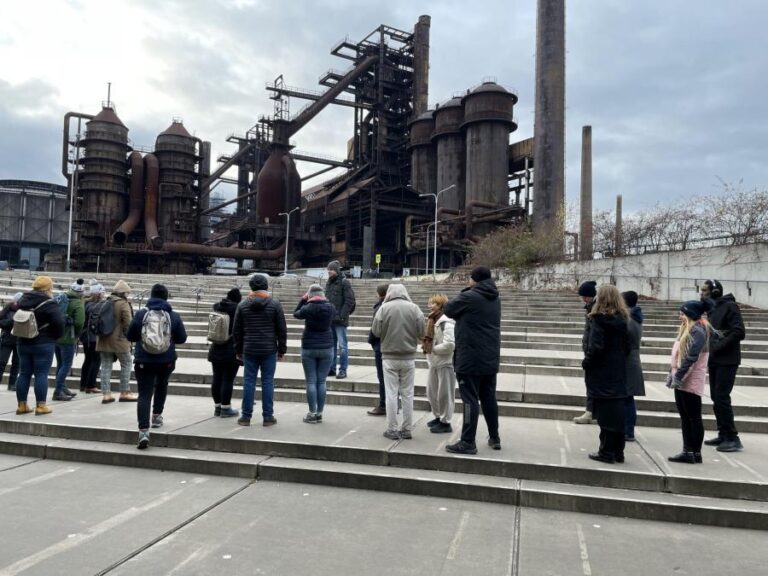 Grupa ludzi przed zabytkową fabryką